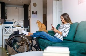 Woman at home wheelchair user sitting on the sofa 